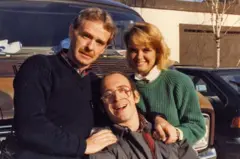 Chuck O'Rear, con una camiseta azul marino, posa con su sonriente hija Stephanie Carpenter con una camiseta verde y su hijo Michael, que tiene una discapacidad.