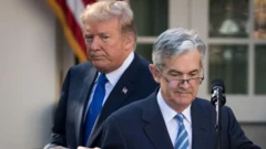 جروم پاول پشت میکروفون، پشت سر او دونالد ترامپ