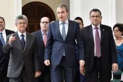 Henry Ramos Allup, Julio Borges, Enrique Márquezy Zapatero caminan uno al lado del otro, todos vestidos con traje de chaqueta y corbata.