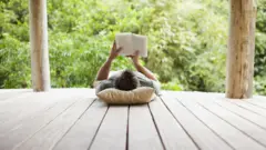 Hombre leyendo libro en el campo