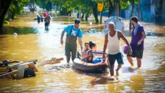 Homens usam bote para resgatar pessoas durante enchentscassino com saque pixPorto Alegre