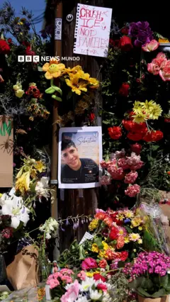 Una foto del joven colombiano abatido por ICE rodeada de flores en un altar en la calle