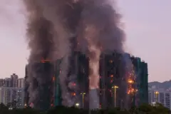 Una panorámica de varios edificios envueltos en denso humo y llamas en sus diferentes pisos