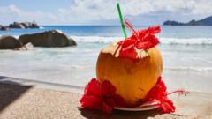 Un coco con flores en una soleada playa con aguas turquesas