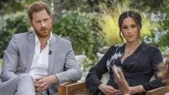 Harry and Meghan speaking to Oprah with credit
