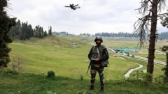 یک سرباز هندی در چمنزاری ایستاده و یک پهپاد را کنترل می‌کند