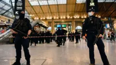 Two armed guards stand near where the attack took place in Paris' Gare du Nord