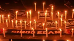 Lit candles are left as a tribute to the victims of the football disaster in Indonesia
