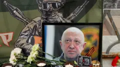 Foto de Prigozhin em meio a velas e flores em homenagem