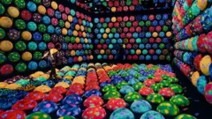 Sala do museu de arte interativo teamLab Planets, em Tóquio, no Japão, repleta de objetos redondos coloridos