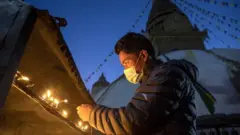 मास्क लगाएर बत्ती बाल्दै