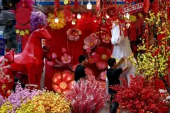 Nhân viên một cửa hàng ở Hà Nội đang trang trí với linh vật ngựa để chuẩn bị đón Tết Nguyên đán 2026