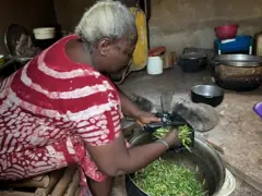 Mama Janet prépare le “Mingwin “ ou “sauterelles verte” pour la vente