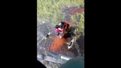 imagem feita a partir de helicoptero mostra passageiros abraçados em meio a um pântano