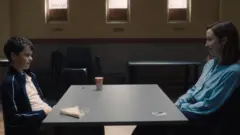 Cooper e Doherty sentados frente a frente