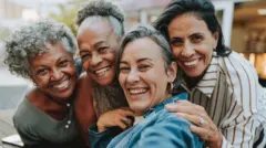4 mujeres se toman un selfie mientras sonrien. 