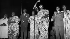 Sylvanus Olympio, premier président du Togo, en pagne, le poing en élevé, proclamant l'indépendance du Togo