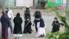 جثت الأخت آن روز نو تاونغ على ركبتيها أمام الضباظ أمام عيادتها في محاولة لإنقاذ المتظاهرين