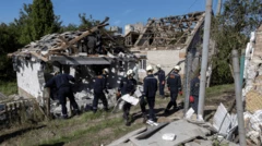 Bombeiros ucranianos removem destroços de uma casa bombardeada.