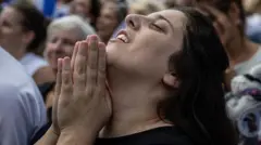 A woman reacts while watching the hostage release live stream at Hostages Square on October 13, 2025 in Tel Aviv, Israel. 