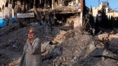 Женщина возле разрушенных зданий в Тегеране, 21 марта