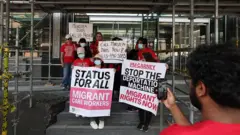 Trabalhadoras domésticas migrantes ocupam o saguão do prédio federal de imigração canadense no Dia Internacional das Trabalhadoras Domésticas (16 de junho). As trabalhadoras, vestidas de vermelho e segurando cartazes, exigem uma reunião com a ministra da Imigração, Lena Diab, em Toronto