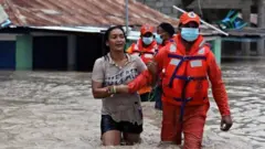 La defensa civil de República Dominicana rescata a una mujer tras las inundaciones causadas por la tormenta Laura.