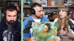 Taylor Swift durante participação no podcast com os irmãos Travis e Jason Kelce. Na imagem, é exibida a capa do seu novo álbum