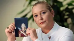 Virginia Giuffre sujeta una fotografía de ella misma más joven