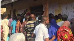Voters wey dey check dia names for displayed voters register 