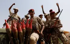 جنود قوات الدعم السريع شبه العسكرية السودانية يحيّون الناس أثناء تأمينهم موقعاً حضر فيه الفريق الركن محمد حمدان دقلو، نائب رئيس المجلس العسكري ورئيس قوات الدعم السريع، اجتماعاً في الخرطوم، السودان، 18 يونيو/حزيران 2019.