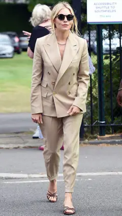 A atriz e modelo britânica Sienna Miller, de roupa bege, chegando às quadras de Wimbledon