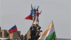 Des manifestants brandissent un drapeau russe