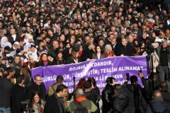 Ön tarafta DEM Parti yönetimi elinde mor bir pankart taşıyor. Arkalarında yüzlerce kişi var. Bir yürüyüşe üstten bakış. 