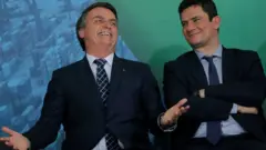 Bolsonaro dá risada ao lado de Moro sorrindo em foto de 2019