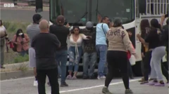 مجموعة من الرجال والنساء تدفع حافلة أحدهم ملثم