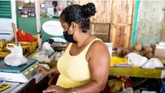 mulher trabalhadora pesa produtos em feira