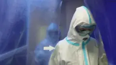 Врач в защитном костюме