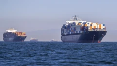 Two full container ships, and two more in the background, in the water outside Los Angeles ports