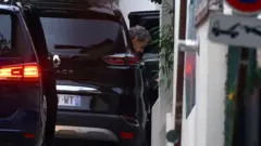 El expresidente de Francia, Nicolas Sarkozy, sale de su auto a la llegada a su casa.
