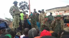 Bernard Byamungu (hagati avuga) umwe mu barwanyi bakuriye M23, arimo kuvugana n'abaturage b'ahitwa Katana ugana i Bukavu nyuma y'uko abo barwanyi bahafashe