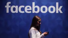 一位女士在Facebook招牌下滑手機