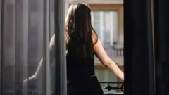 young woman front behind looking out window