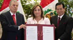 La presidenta Boluarte posa con un ejemplar firmado de la Ley de Amnistía junto a su primer ministro, Eduardo Arana, (d) y el congresista Fernando Rospigliosi (i). 