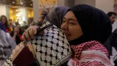 Birbirine sevinçle sarılan iki başörtülü kadın 