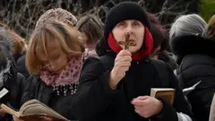 십자가를 들고 서 있는 시민의 모습