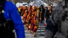 Бхикху Паннакара (C) и другие буддийские монахи, участвующие в акции «Марш за мир», приближаются к Капитолию США в Вашингтоне, округ Колумбия, США, 11 февраля 2026 года. 