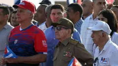 Raúl Castro, usando uniforme militar, ao lado do presidente de Cuba, Miguel Díaz-Canel
