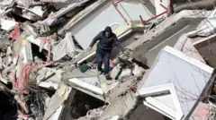 Un hombre camina entre los escombros de un edificio derrumbado en Kahramanmarash el día después de que un terremoto de 7,8 grados de magnitud azotara el sureste de Turquía.
