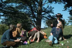 Un grupo de jóvenes sentandos en un parque.